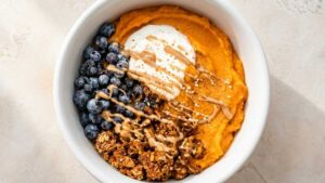 Fluffy whipped sweet potato breakfast bowl topped with granola and fresh berries