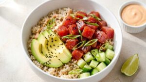 Spicy tuna poke bowl with avocado, cucumber, and spicy mayo drizzle over rice
