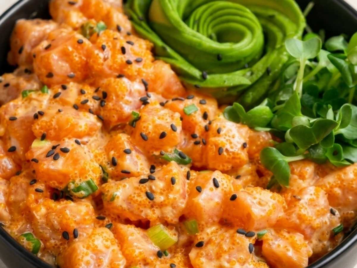 Close-up of spicy salmon poke bowl showing creamy sriracha-coated salmon