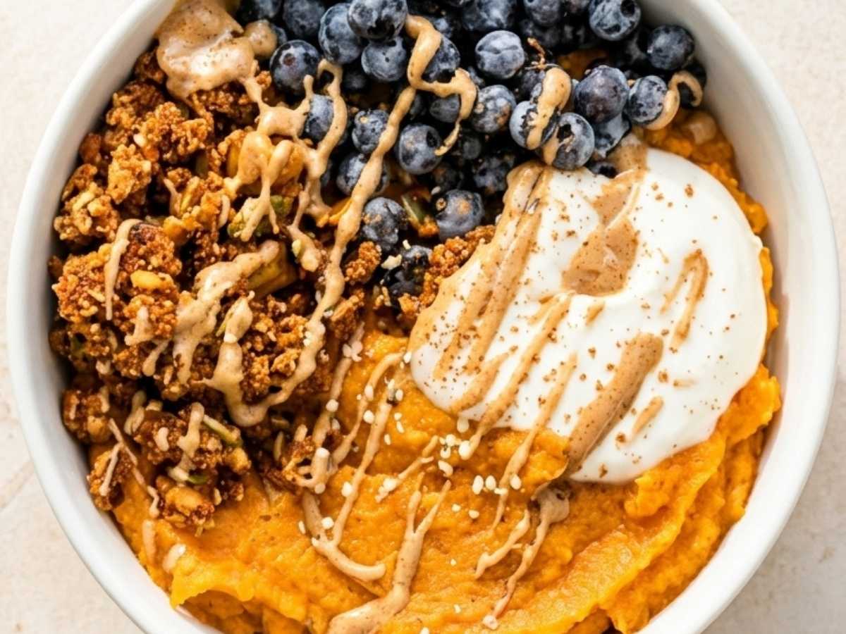 Closeup of creamy whipped sweet potato breakfast bowl with cinnamon and berries