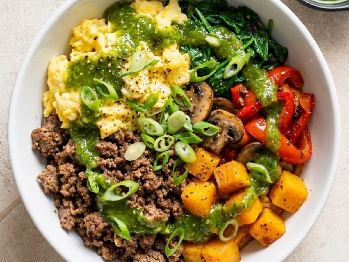Close up of beef protein bowl topped with avocado, salsa, and a fried egg