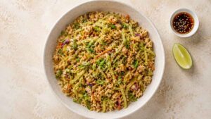 Wide angle shot of chicken egg roll in a bowl topped with sesame seeds and green onions