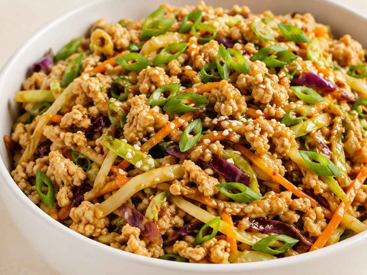 Close up of chicken egg roll in a bowl showing crispy cabbage and browned ground chicken