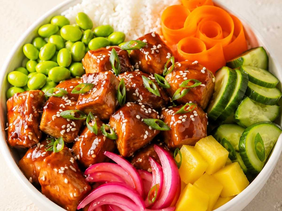 Close up of caramelized teriyaki chicken over sushi rice in a finished poke bowl