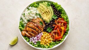 Fajita Chicken Burrito Bowl Fajita chicken burrito bowl with sliced chicken, charred peppers, cilantro lime rice, black beans, corn and avocado