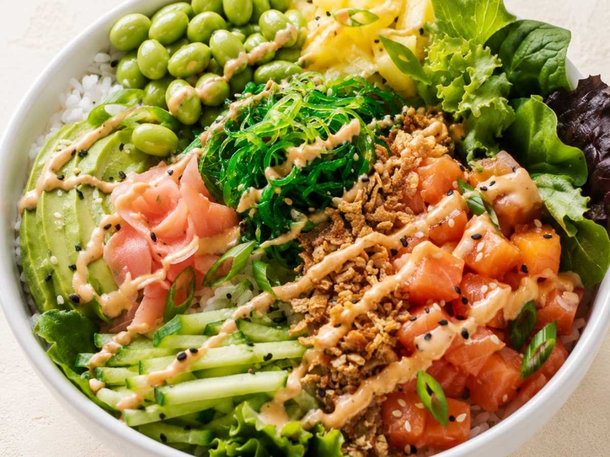 Closeup of a Hawaiian poke bowl drizzled with spicy aioli and sesame vinaigrette