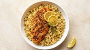One Pot Lemon Herb Chicken & Rice Bowl Overhead wide angle shot of a one pot lemon herb chicken and rice bowl with sliced chicken over lemony rice