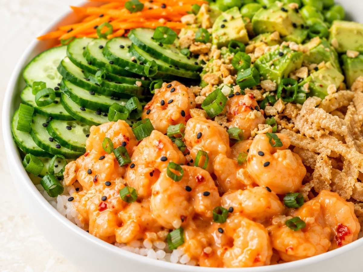 Close up of shrimp poke bowl topped with avocado, edamame and crushed peanuts