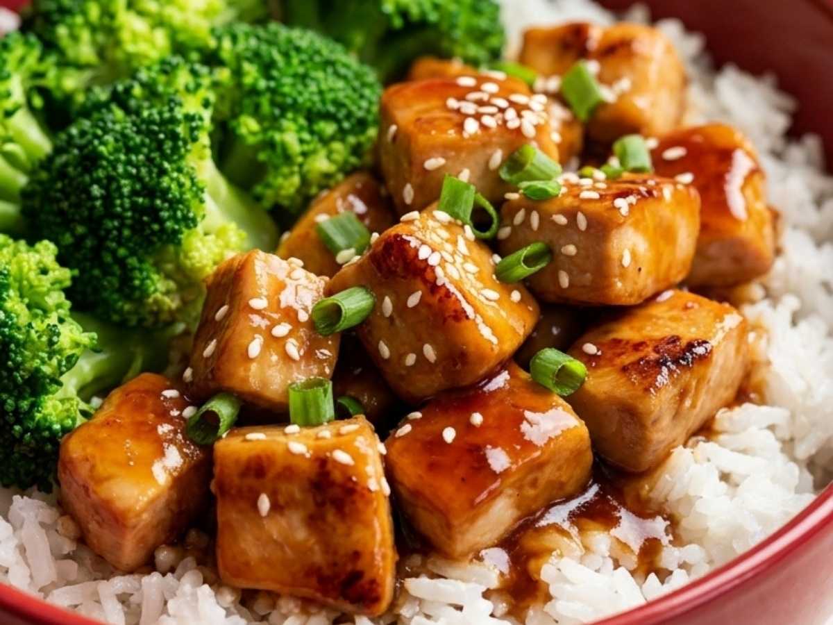 Close-up of glossy teriyaki chicken over rice in a Teriyaki Chicken Rice Bowl