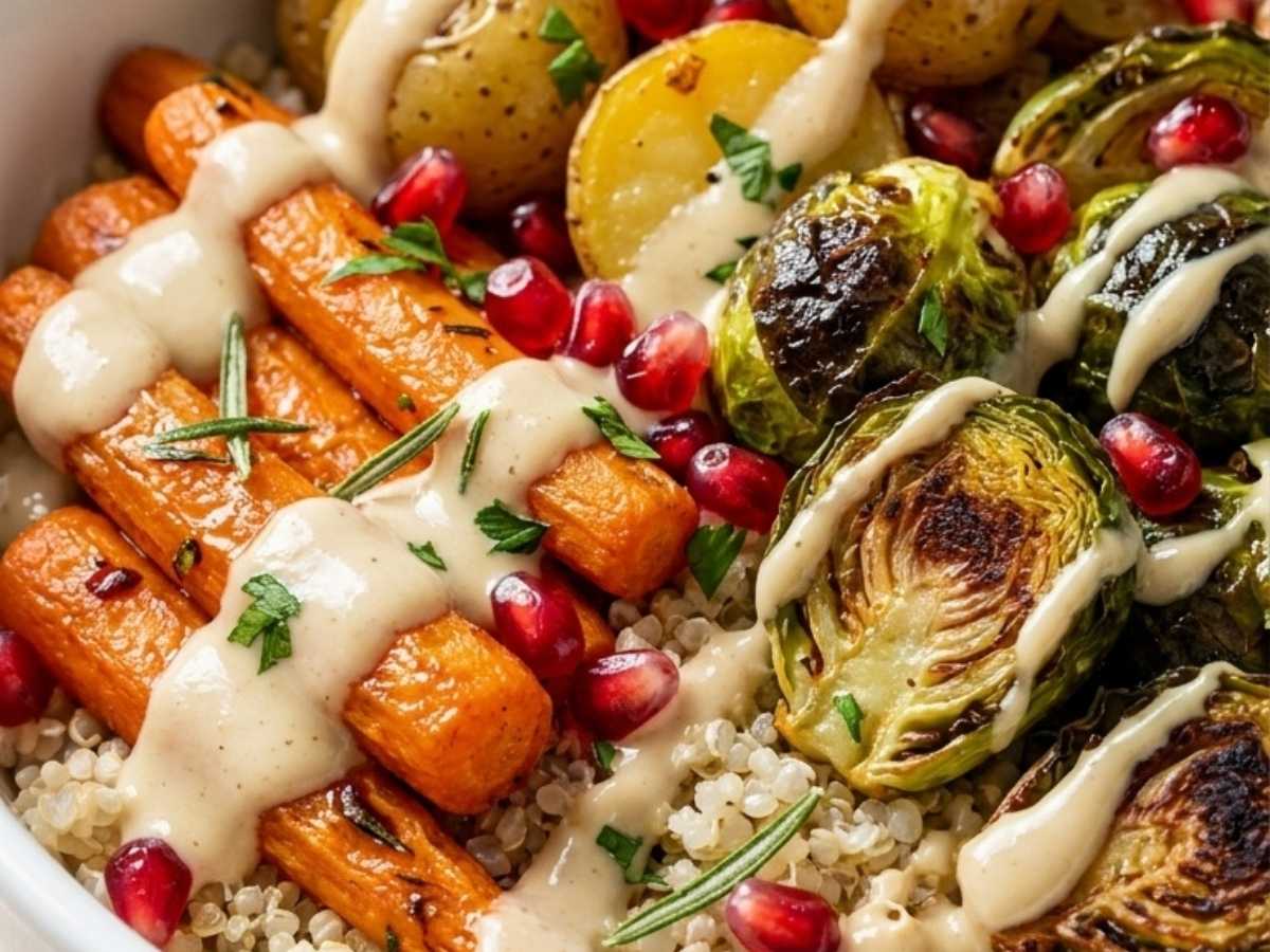Close-up of quinoa, roasted carrots, and Brussels sprouts topped with pomegranate arils and tahini dressing