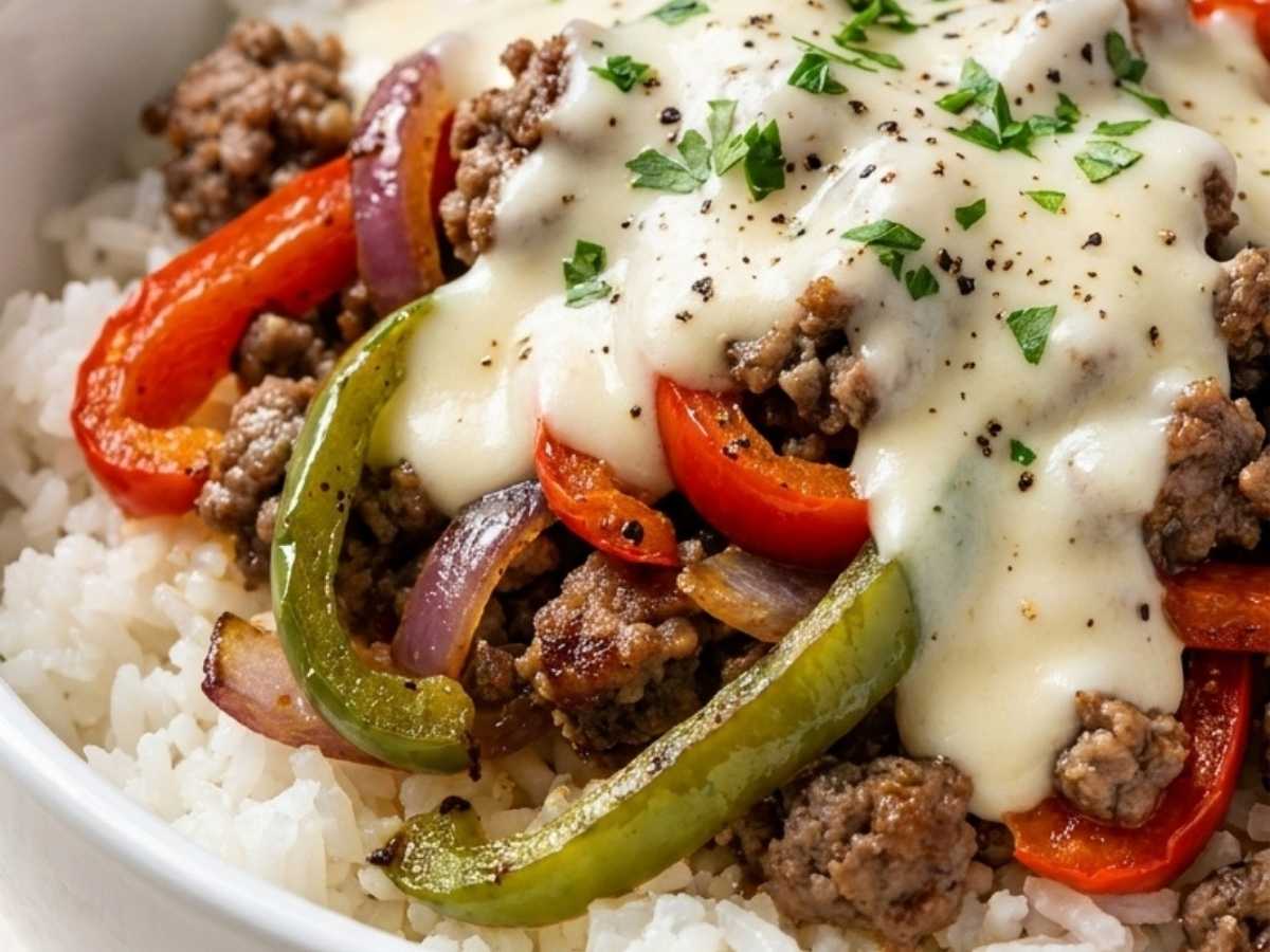 Close up of Philly Cheesesteak Rice Bowl showing melted cheese sauce over beef and rice