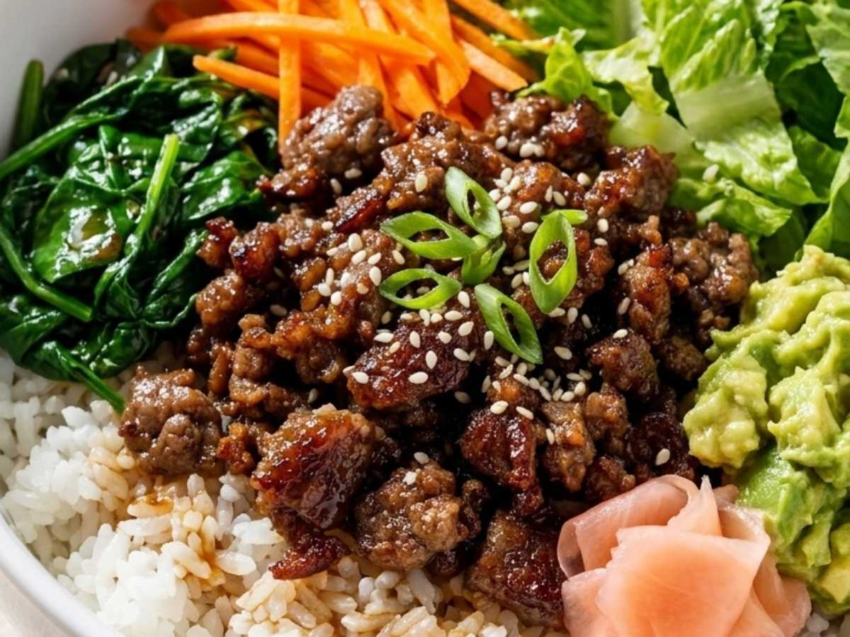 Close up of caramelized ground beef bulgogi over rice with sesame seeds and green onion