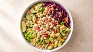 Crab Sushi Bowl Overhead view of a crab sushi bowl with brown rice, avocado, pickled cabbage, and chilli dressing