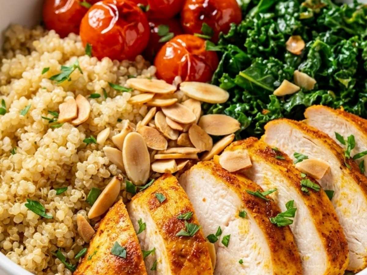 Close-up of a Healthy Chicken Quinoa Bowl showing sliced chicken, charred kale and toasted almonds over quinoa