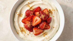 High Protein Cheesecake Bowl Wide overhead shot of a High Protein Cheesecake Bowl topped with sliced strawberries and graham cracker crumbs