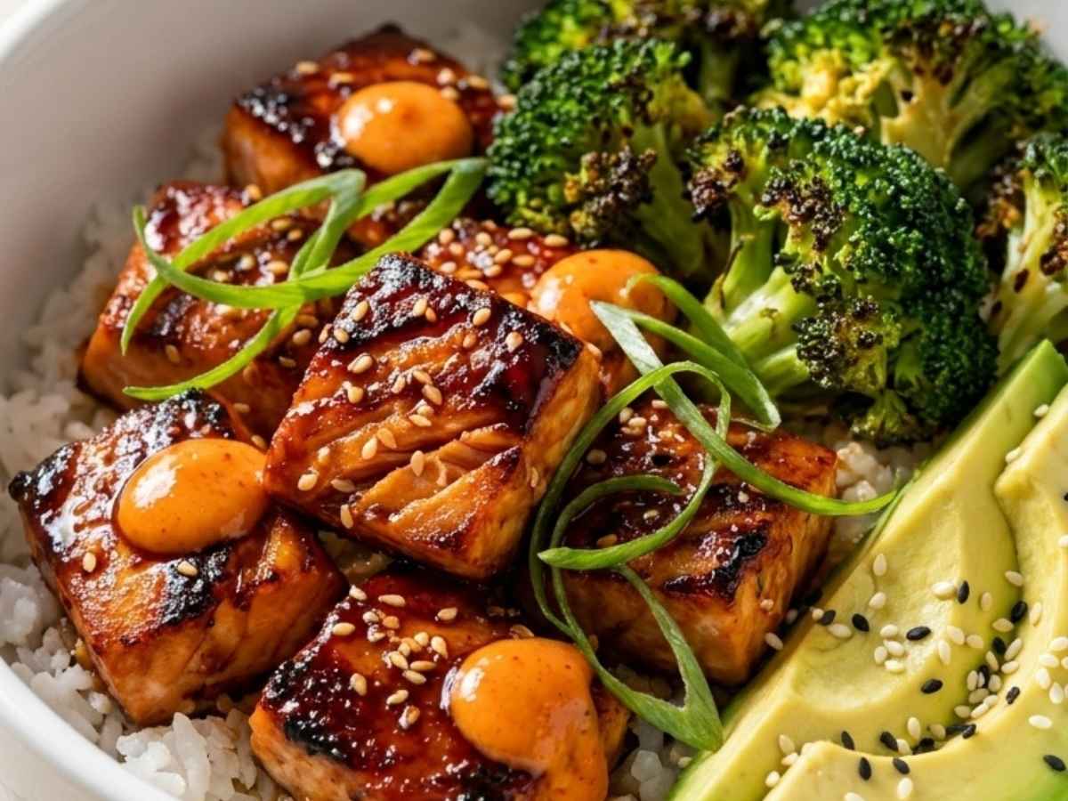 Close up of glossy honey garlic glazed salmon over coconut rice with sesame seeds