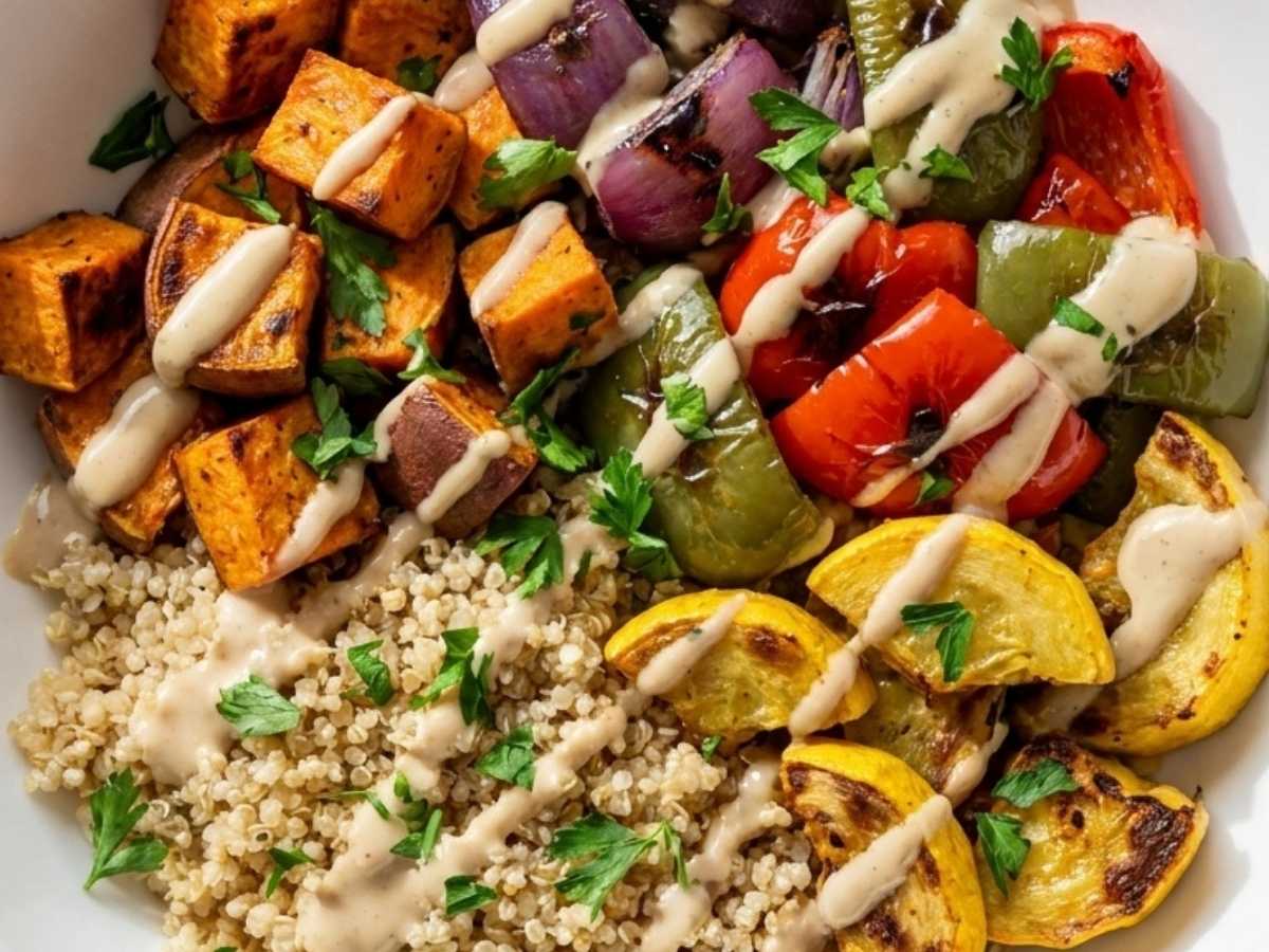 Close up of roasted sweet potato, peppers, and quinoa drizzled with tahini