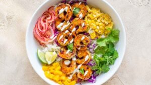 Shrimp Taco Bowl Shrimp taco bowl with jasmine rice, mango, corn, cabbage, and cilantro lime crema