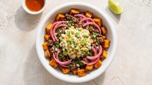 Street Corn Taco Beef Bowl Street corn taco beef bowl with sweet potatoes, ground beef, and creamy corn topping in a bowl